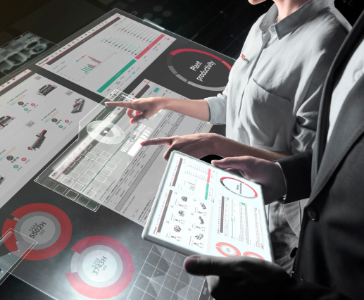 Dos personas consultan dashboards de software TCI en mesa táctil y tablet
