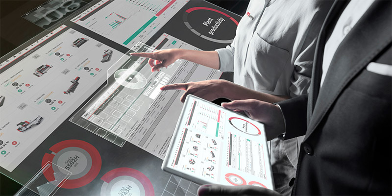 Dos personas consultando TCI Manager en mesa táctil y tablet