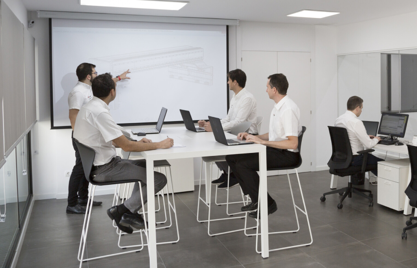 Ingenieros de TCI Cutting revisan plano CAD 3D en pantalla de proyección