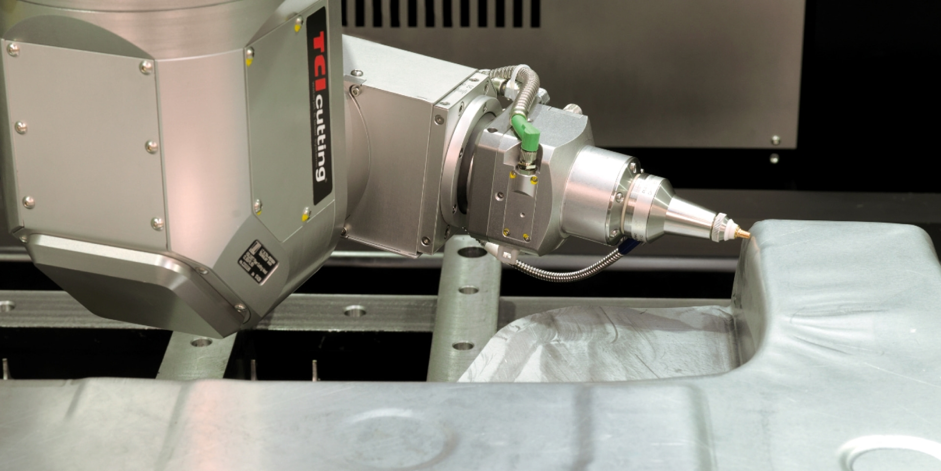 TCI Cutting 3D robotic cutting head trimming a contoured metal workpiece