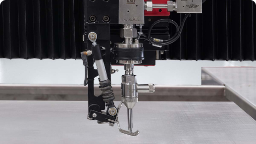 KMT waterjet cutting head with height sensor nozzle above a metal workpiece