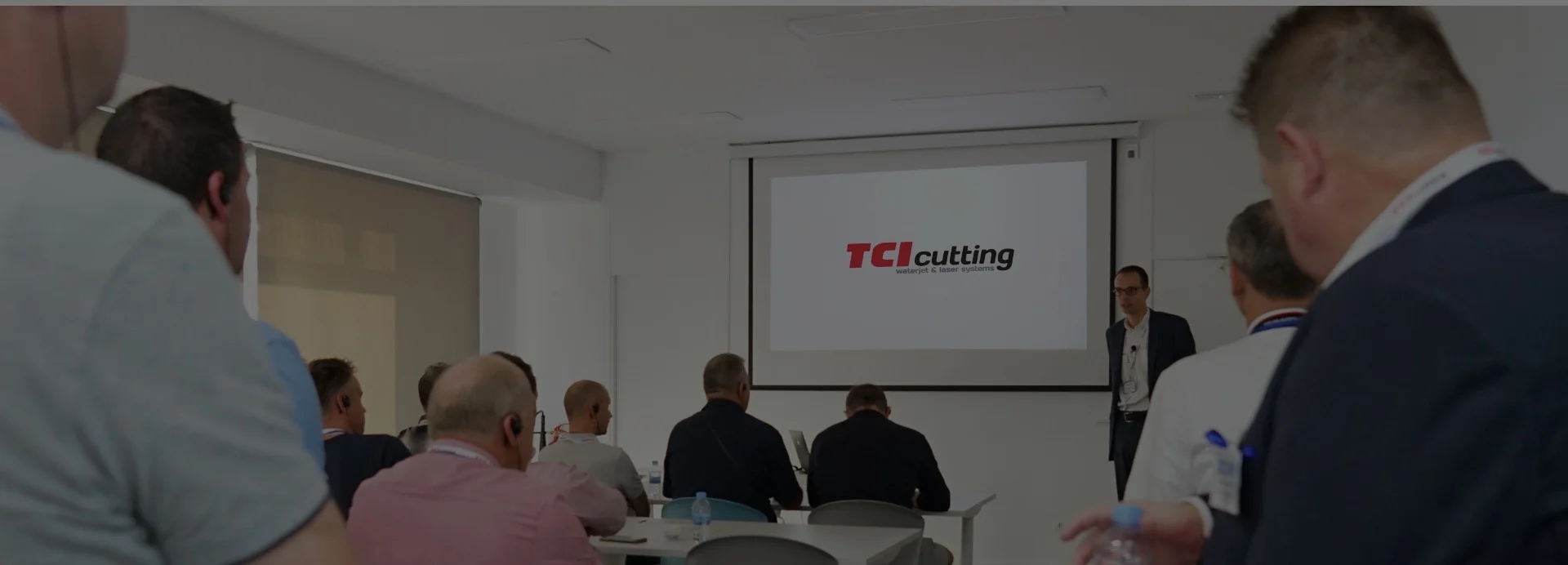 TCI Cutting training session with logo on screen and seated audience